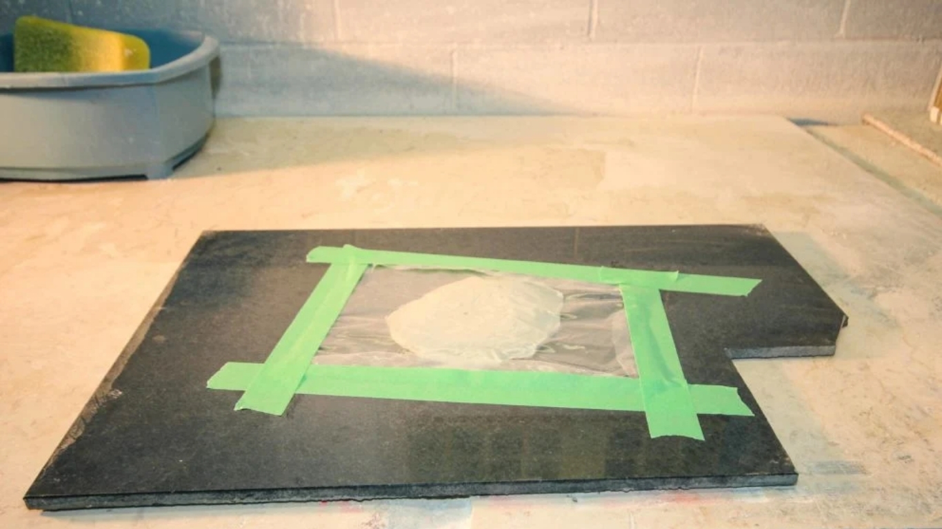 Vết bẩn đã được đắp poultice, che lại bằng màng nhựa và dán băng keo giấy.